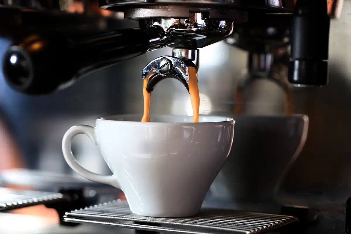 Espressor care toarnă cafea într-o ceașcă albă